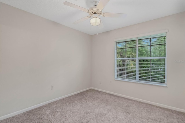 carpeted spare room featuring ceiling fan