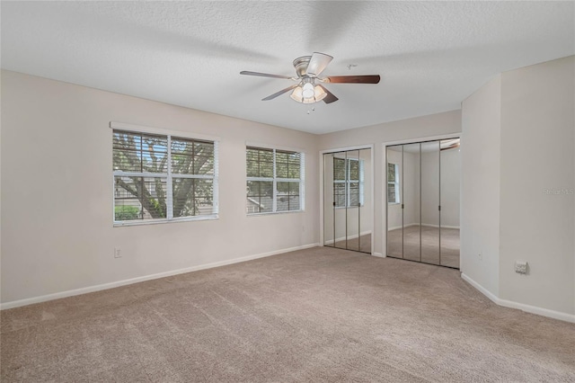 carpeted empty room with a textured ceiling and ceiling fan