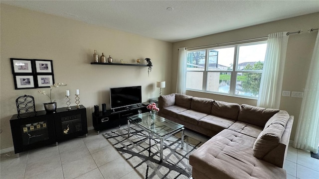 living room with a textured ceiling and light tile patterned flooring