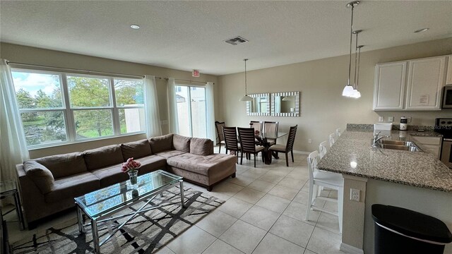 tiled living room featuring a textured ceiling and sink