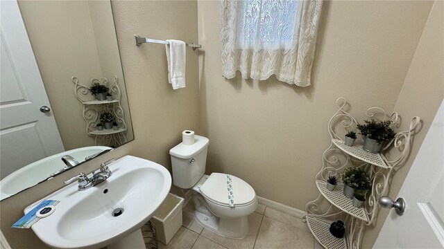 bathroom with sink, toilet, and tile patterned floors