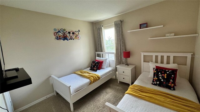 bedroom featuring dark carpet and a textured ceiling