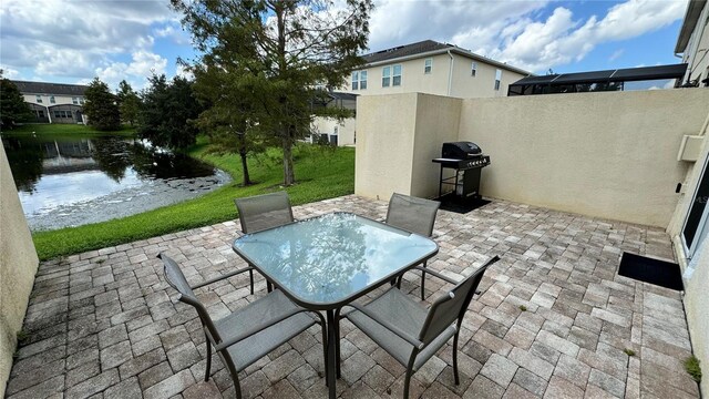 view of patio / terrace featuring a water view and a grill