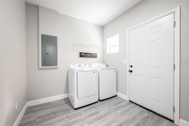 clothes washing area featuring light hardwood / wood-style flooring, washing machine and clothes dryer, and electric panel