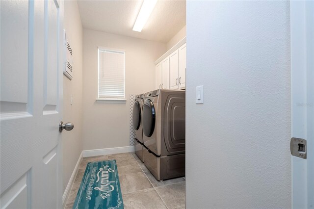 clothes washing area featuring light tile patterned floors, separate washer and dryer, and cabinets