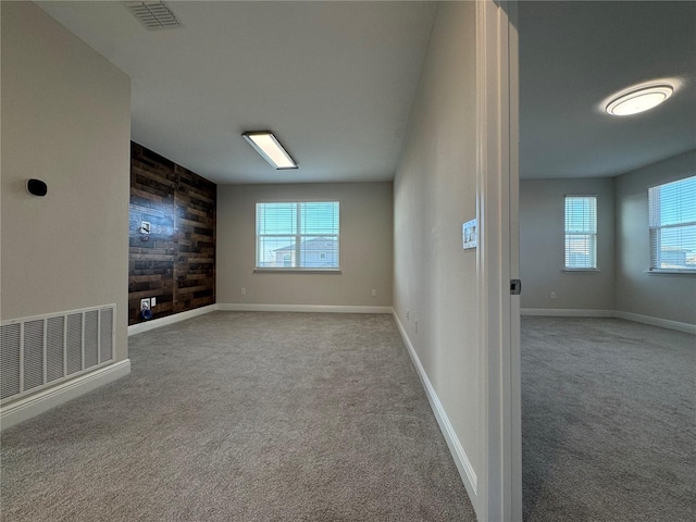 unfurnished room featuring plenty of natural light and light colored carpet