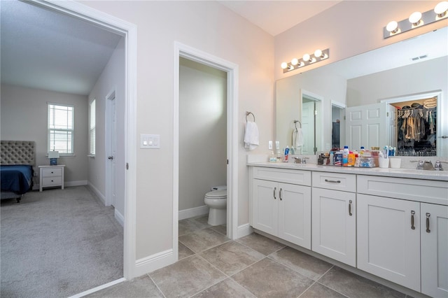 bathroom with toilet, tile patterned flooring, and vanity