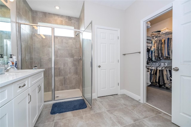 bathroom with tile patterned floors, walk in shower, and vanity