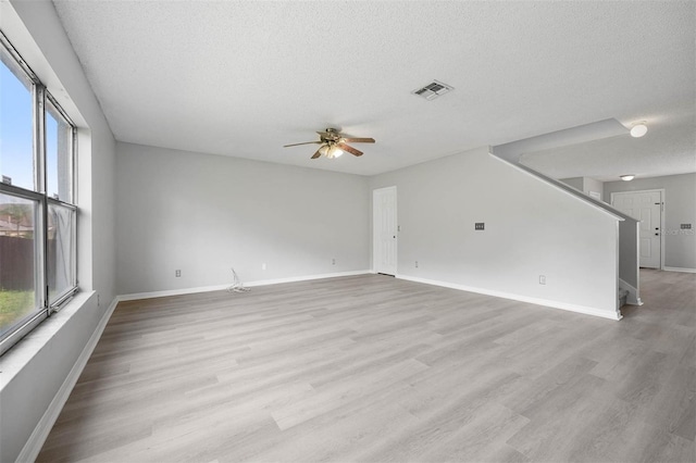 unfurnished living room featuring a textured ceiling, ceiling fan, and light hardwood / wood-style floors