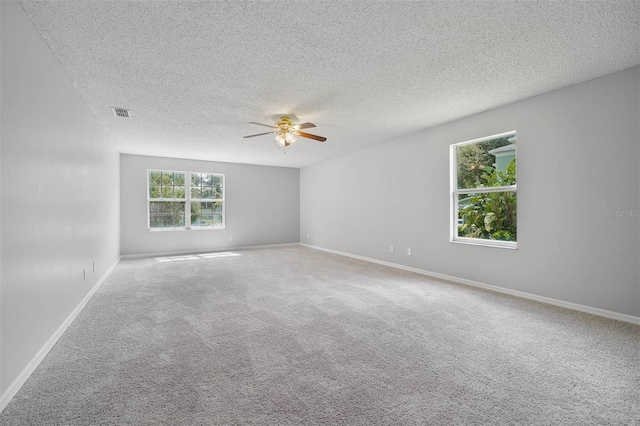 carpeted empty room with ceiling fan and a textured ceiling