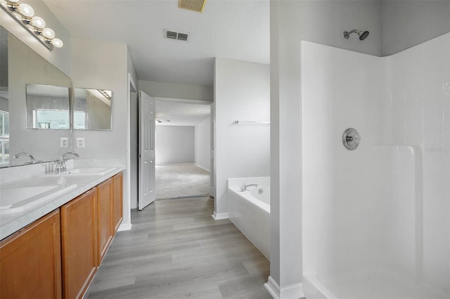 bathroom featuring separate shower and tub, hardwood / wood-style flooring, and vanity