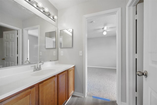 bathroom featuring vanity, a textured ceiling, hardwood / wood-style flooring, and ceiling fan