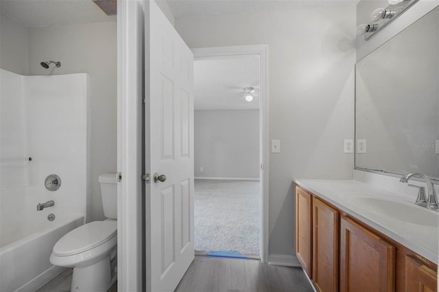 full bathroom with toilet, hardwood / wood-style floors, vanity, shower / tub combination, and ceiling fan