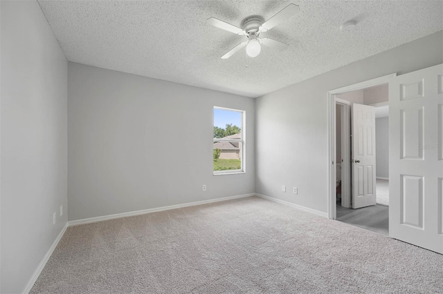 unfurnished bedroom featuring light colored carpet, ceiling fan, and a textured ceiling