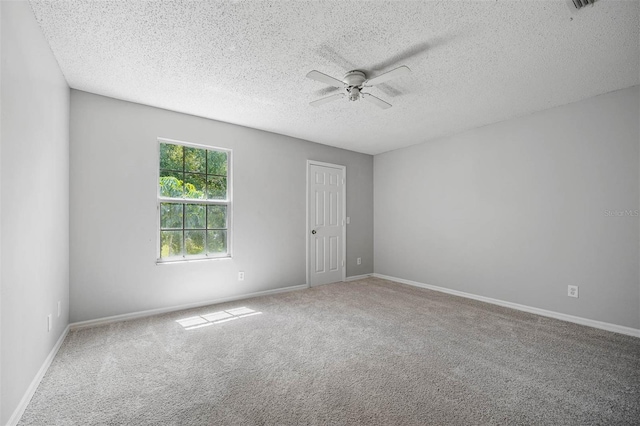 empty room featuring ceiling fan, carpet, and a textured ceiling