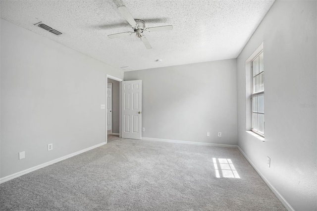 carpeted empty room featuring a textured ceiling and ceiling fan