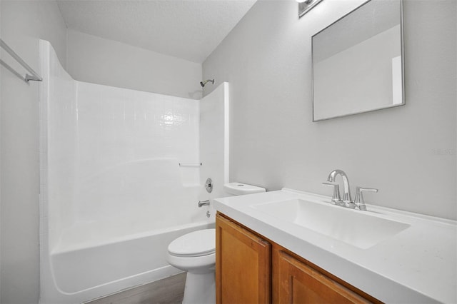 full bathroom with a textured ceiling, vanity, hardwood / wood-style floors, toilet, and bathtub / shower combination