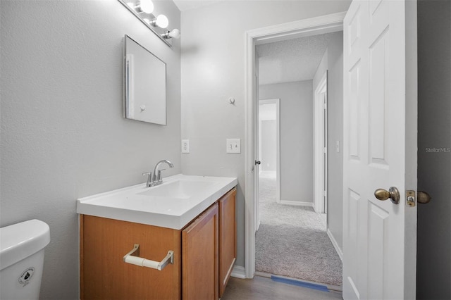 bathroom featuring vanity, toilet, and a textured ceiling