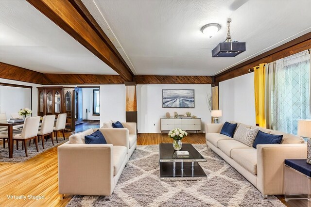 living room featuring beam ceiling and hardwood / wood-style floors