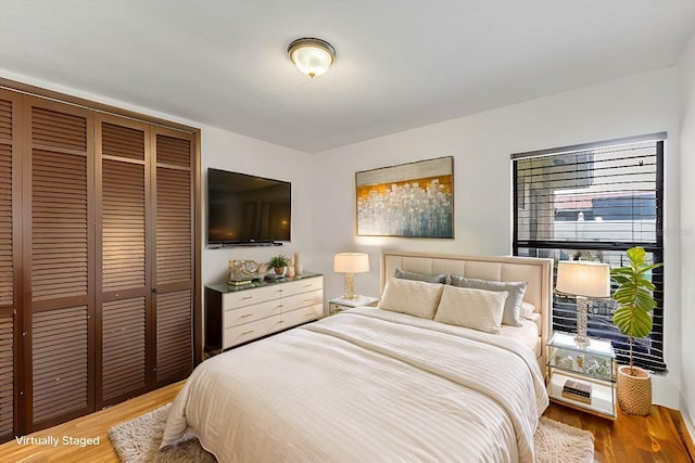 bedroom with wood-type flooring and a closet