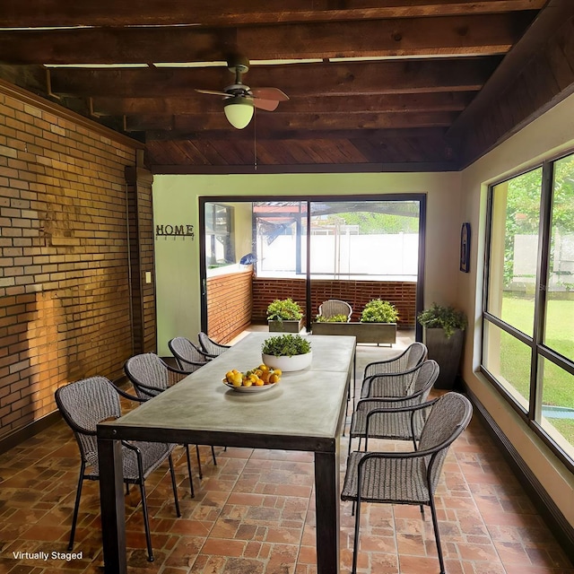 sunroom / solarium featuring beamed ceiling and ceiling fan