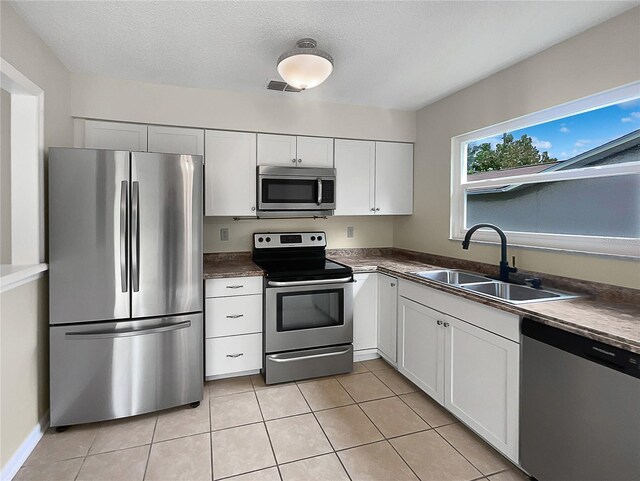 kitchen featuring white cabinets, appliances with stainless steel finishes, a textured ceiling, and sink