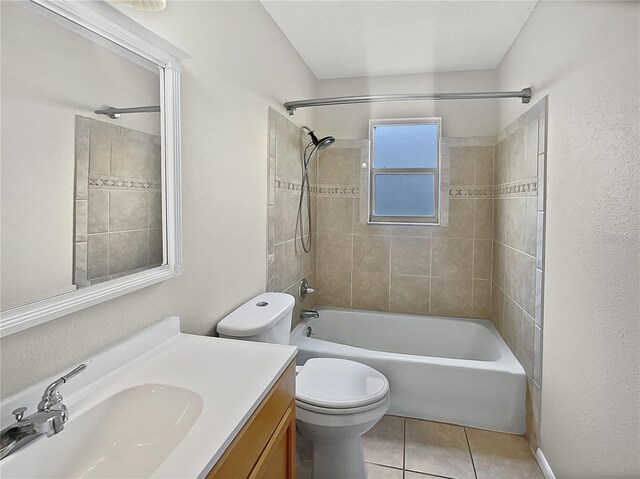 full bathroom featuring tiled shower / bath, vanity, toilet, and tile patterned flooring