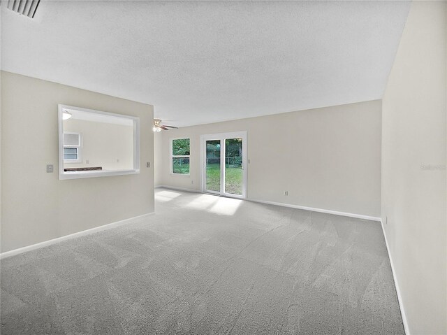 carpeted empty room featuring a textured ceiling and ceiling fan