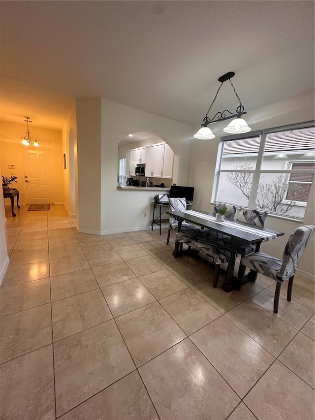 tiled dining area with a chandelier