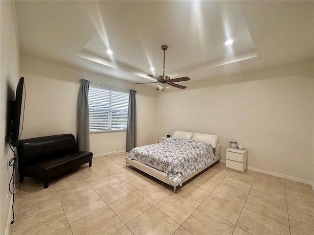 tiled bedroom featuring a tray ceiling and ceiling fan