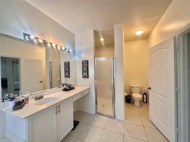 bathroom featuring vanity, toilet, a shower with shower door, and tile patterned floors