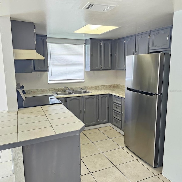 kitchen featuring gray cabinetry, light tile patterned floors, stainless steel appliances, sink, and kitchen peninsula