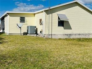 rear view of house with a lawn and central AC unit