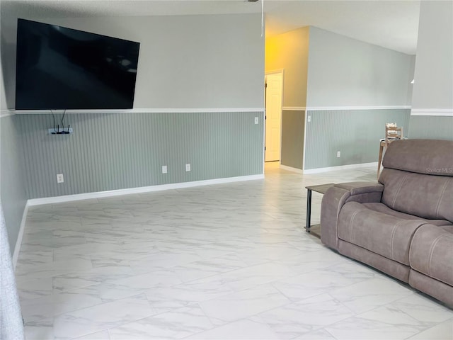 living area with a wainscoted wall and marble finish floor