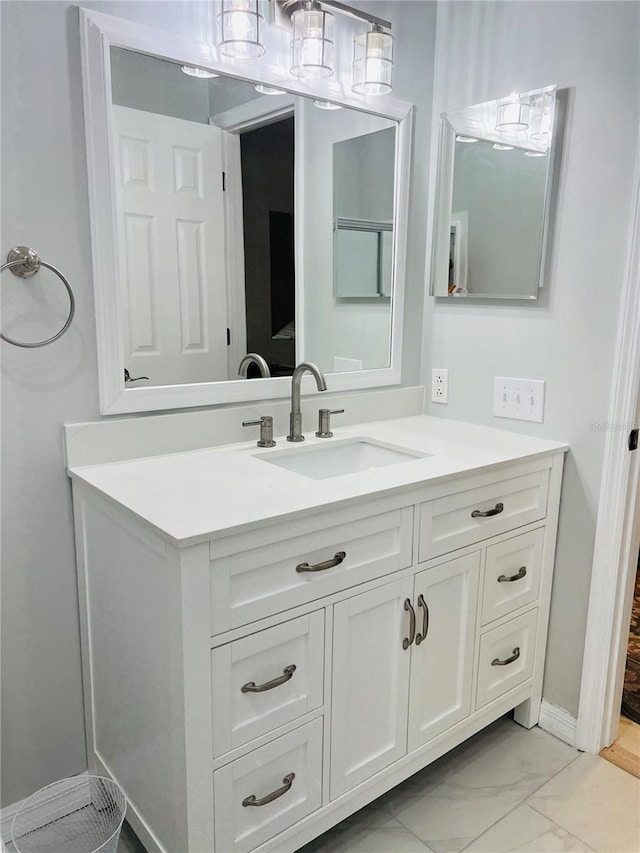 bathroom featuring vanity, baseboards, and marble finish floor