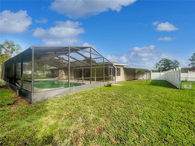 back of house with glass enclosure and a yard