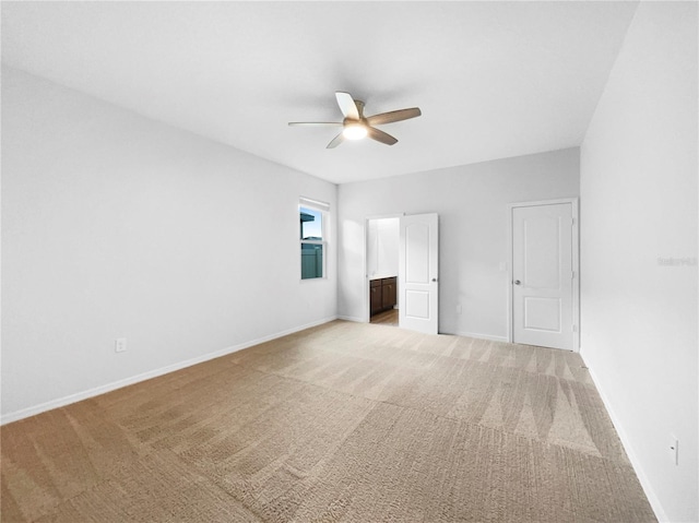 unfurnished bedroom featuring a ceiling fan, light colored carpet, baseboards, and connected bathroom