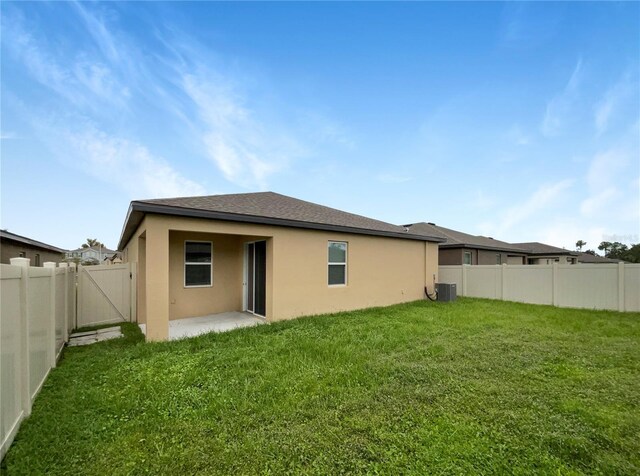 back of house featuring central air condition unit, a yard, and a patio