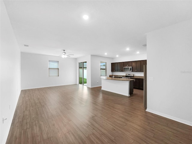 unfurnished living room with a ceiling fan, a sink, dark wood finished floors, recessed lighting, and baseboards