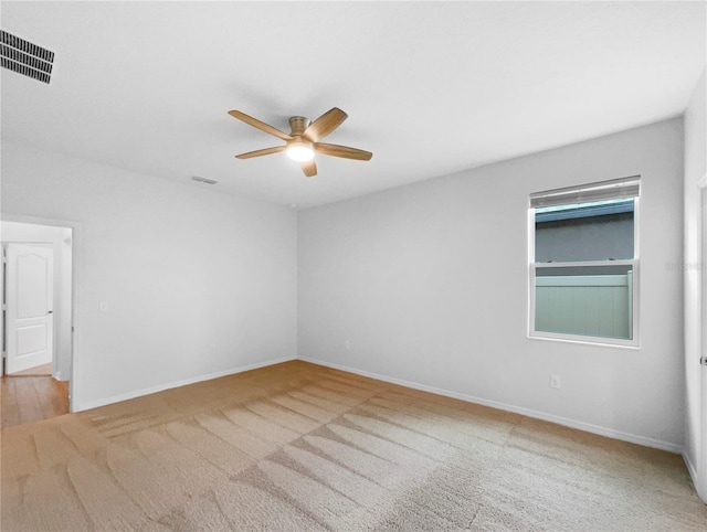 empty room featuring visible vents, baseboards, ceiling fan, and carpet floors