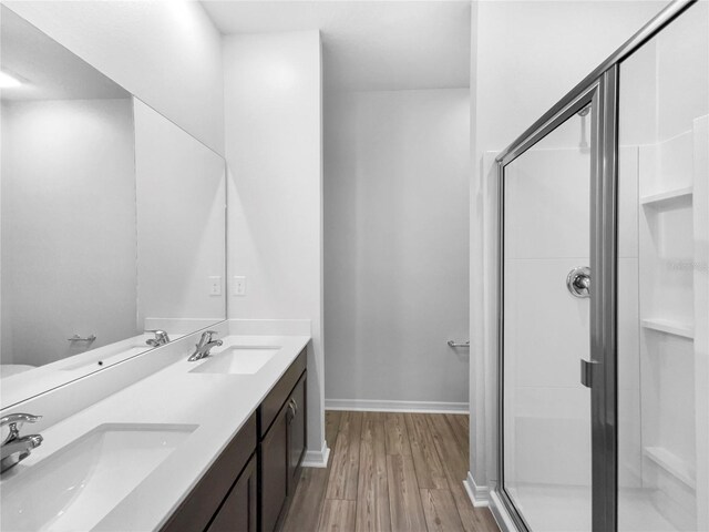 bathroom featuring vanity, hardwood / wood-style floors, and a shower with shower door