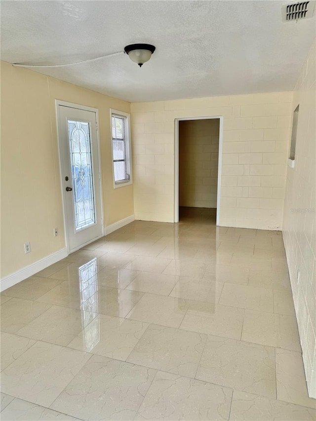 unfurnished room with a textured ceiling