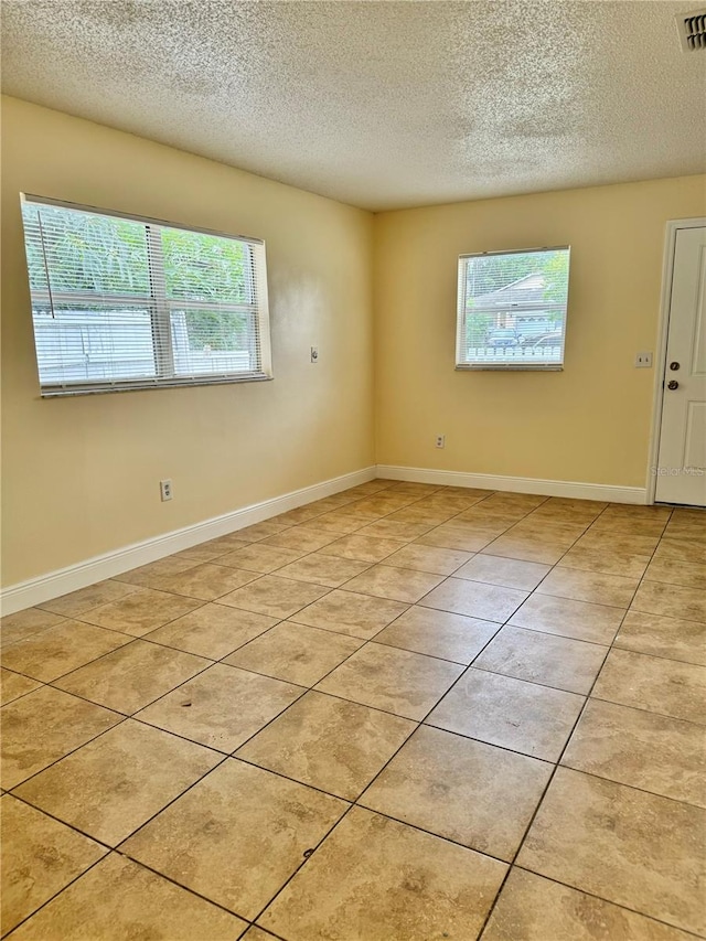 unfurnished room featuring light tile patterned floors and a textured ceiling