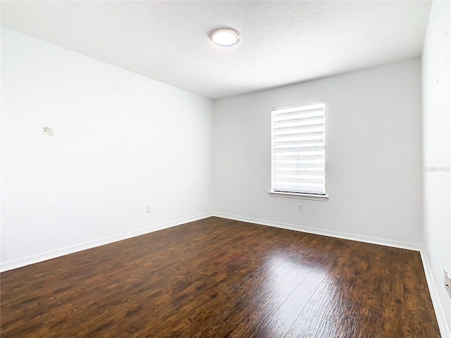 unfurnished room featuring dark hardwood / wood-style flooring