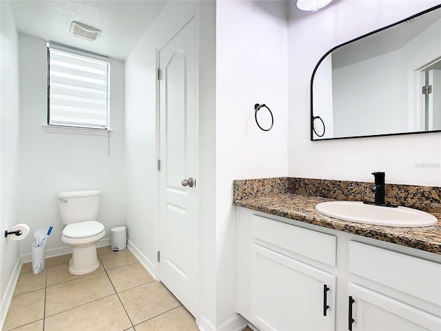 bathroom with vanity, toilet, a textured ceiling, and tile patterned flooring