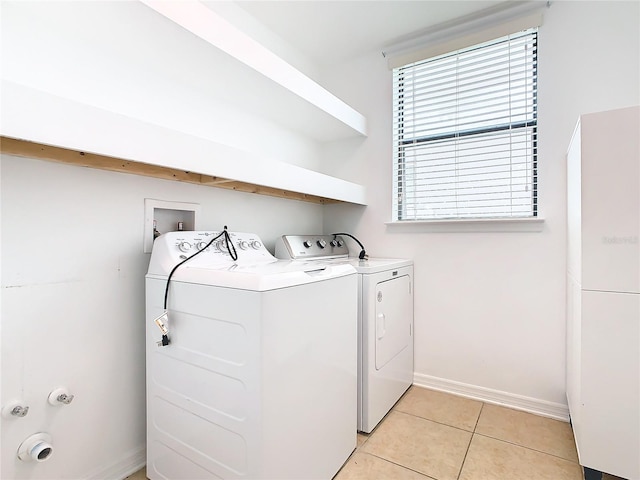 clothes washing area with light tile patterned floors and washer and dryer