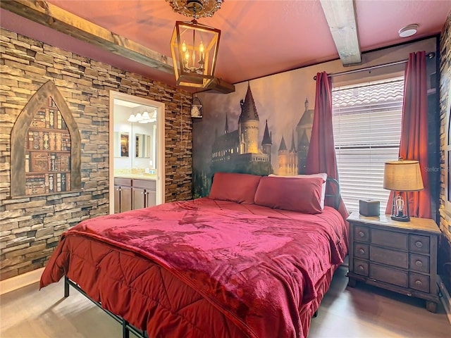 bedroom featuring a chandelier, ensuite bathroom, and beam ceiling