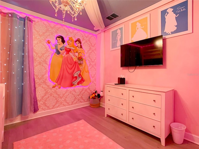 bedroom with light hardwood / wood-style flooring and a chandelier