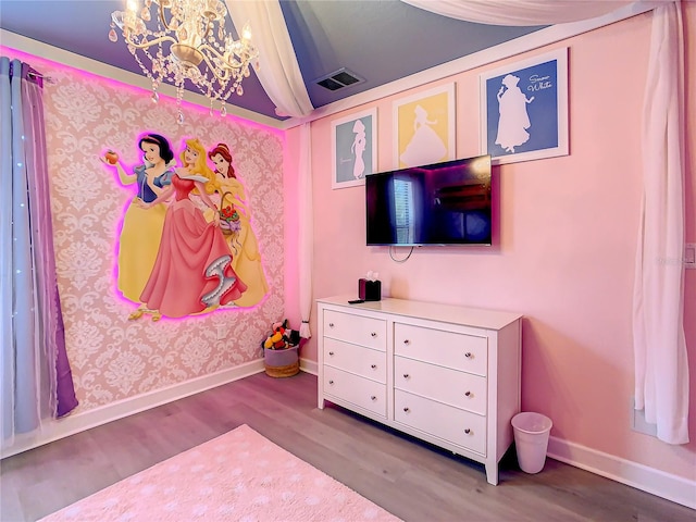 bedroom with an inviting chandelier and wood-type flooring