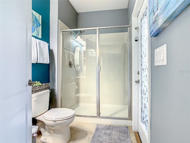 bathroom with walk in shower, toilet, and tile patterned floors